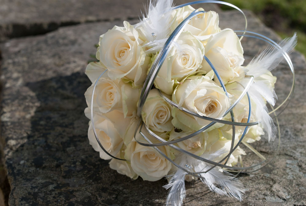 The bride's cream bouquet on the stone floor outside at Simonstone Hall Hotel