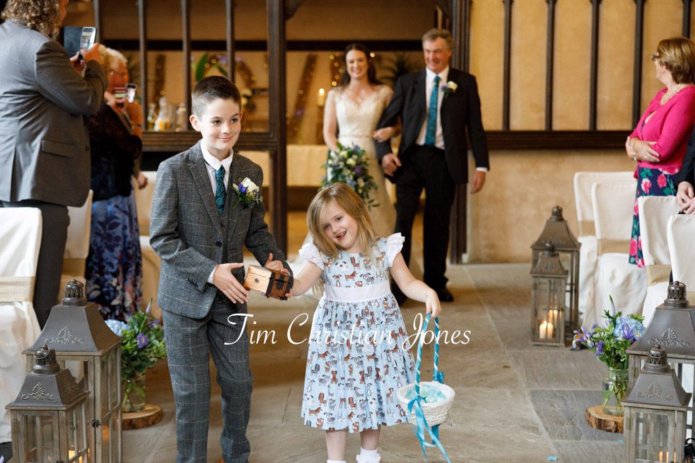 Joyful wedding moment – young bridal party walking down the aisle with flower petals