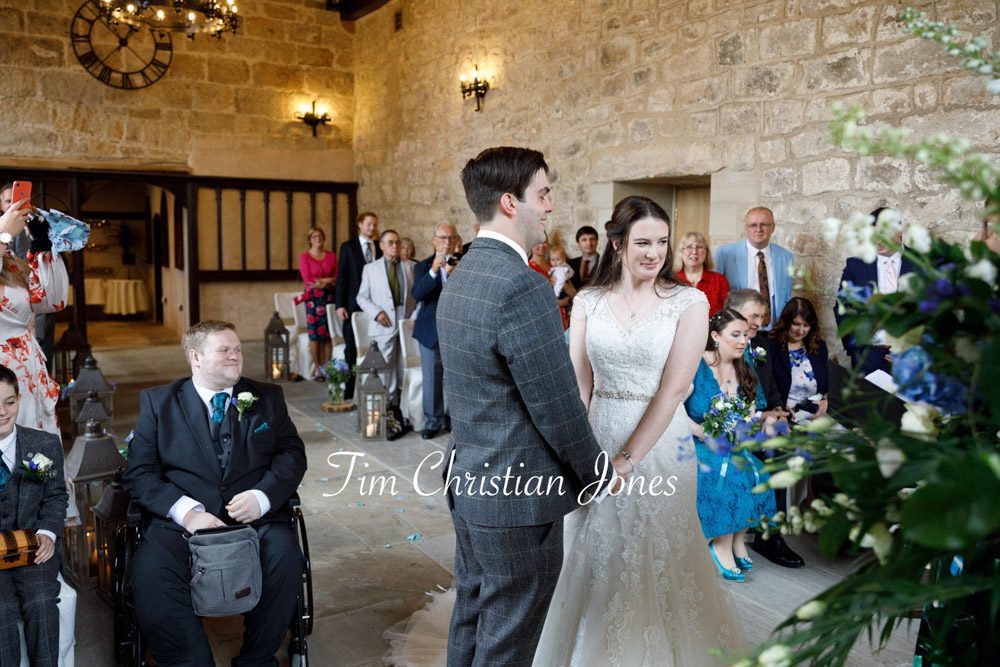 Tender moment during The Priests House ceremony as couple hold hands.