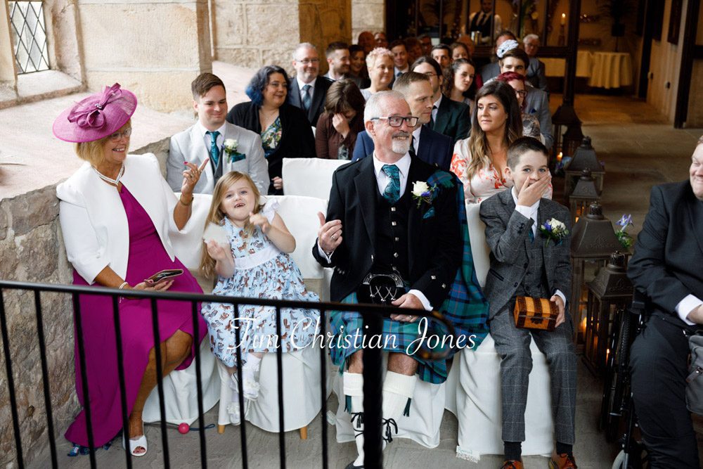 Candid wedding photography – guests react to the ceremony.
