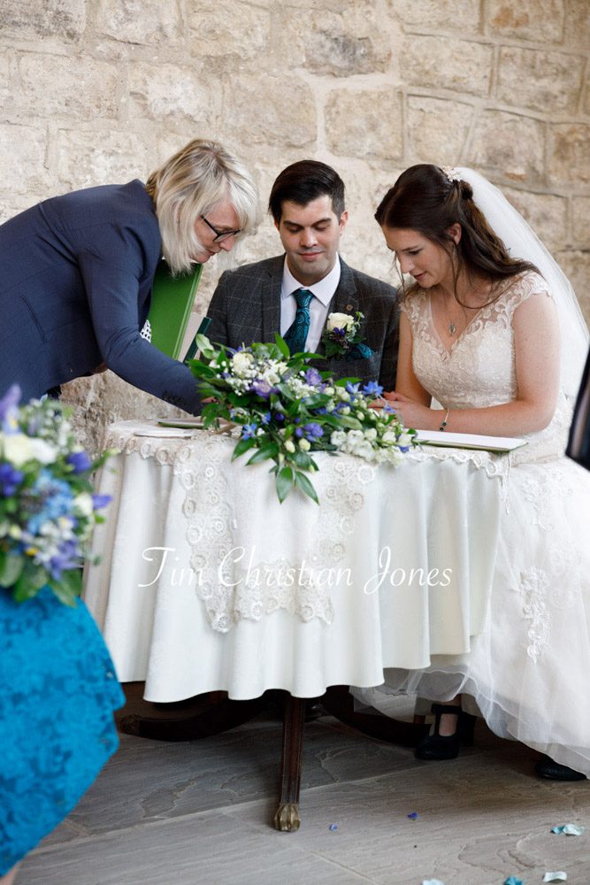 Natural wedding photography of register signing moment.
