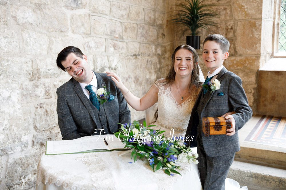 A joyful moment as the pageboy joins the wedding couple at The Priests House, Barden Tower.