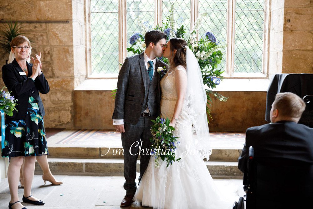 Romantic Yorkshire wedding moment as the newlyweds kiss before leaving the ceremony at Barden Tower.