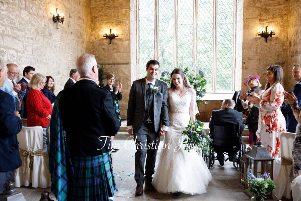 Candid wedding photo of bride and groom leaving The Priests House ceremony.