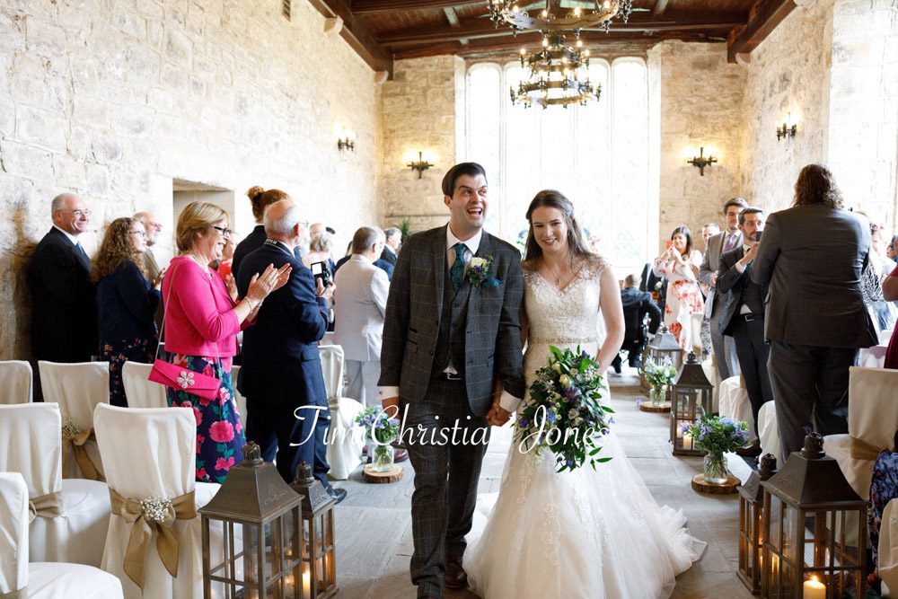 Happy groom celebrating as couple exits ceremony at romantic Yorkshire wedding
