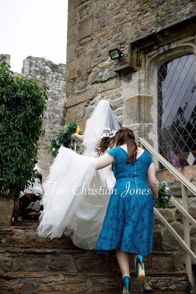 Bridesmaid lifts dress train