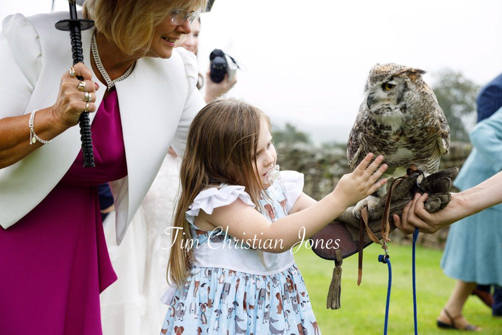 Candid moment of bridesmaid and owl at Barden Tower wedding