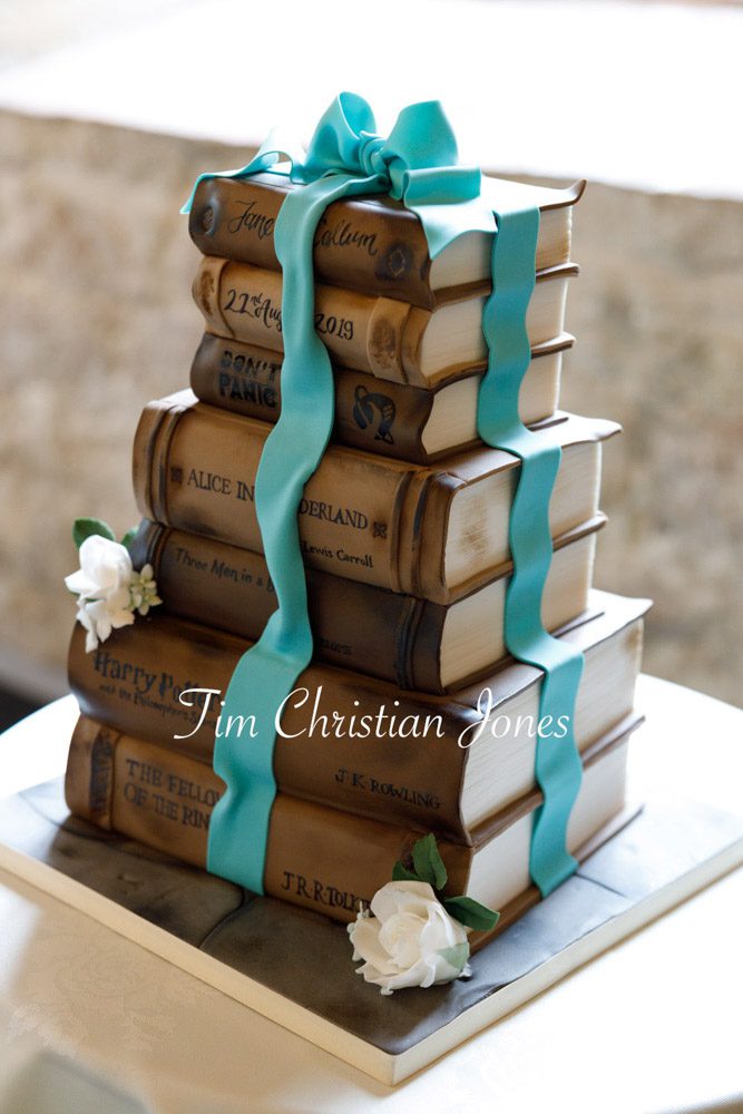 Creative wedding cake styled like a pile of books.