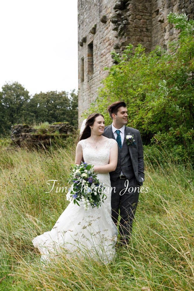 Bride and groom share a tender moment in the meadow at their Yorkshire wedding.