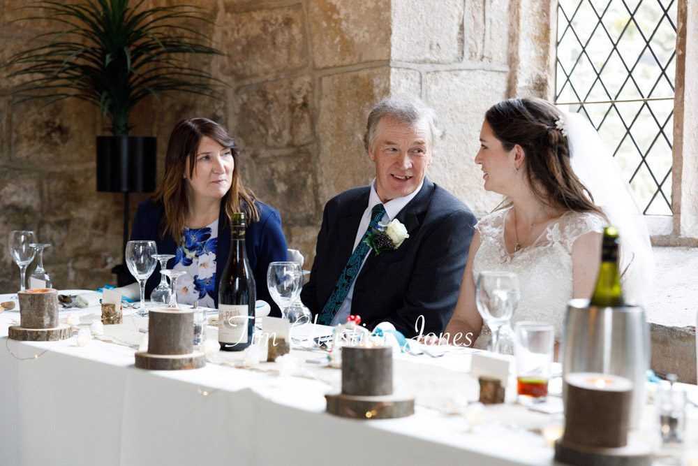 Natural wedding photo of bride chatting with parents at Barden Tower.