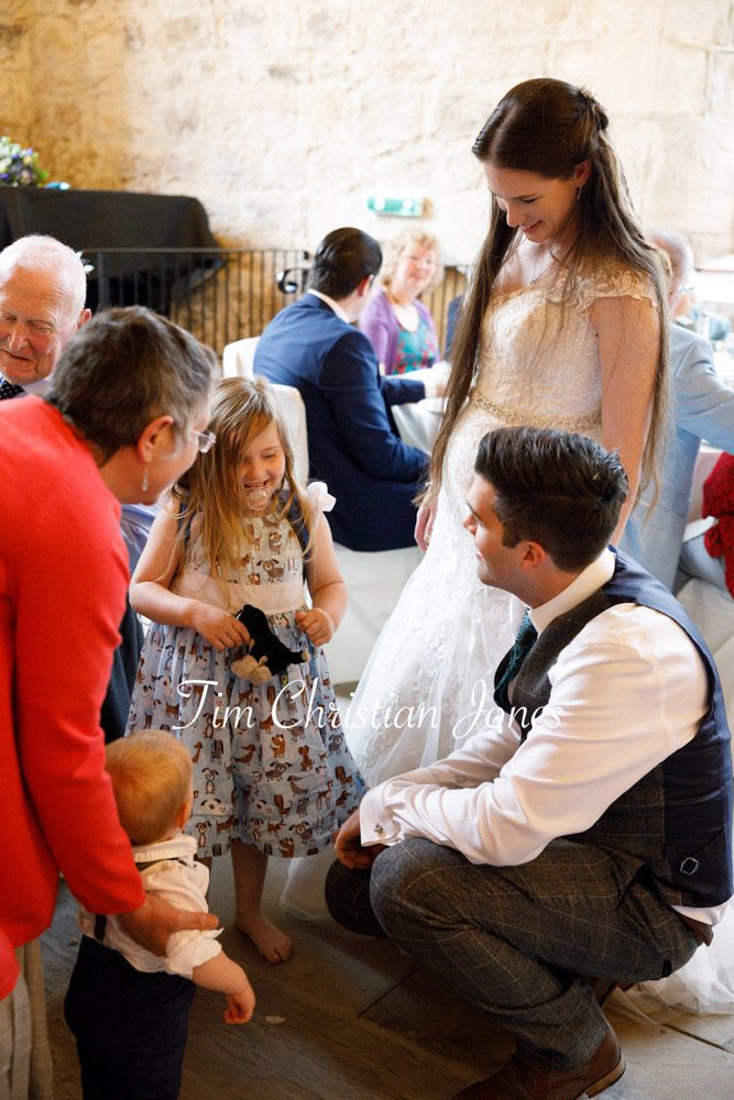 Candid moment as the groom speaks to the little bridesmaid.