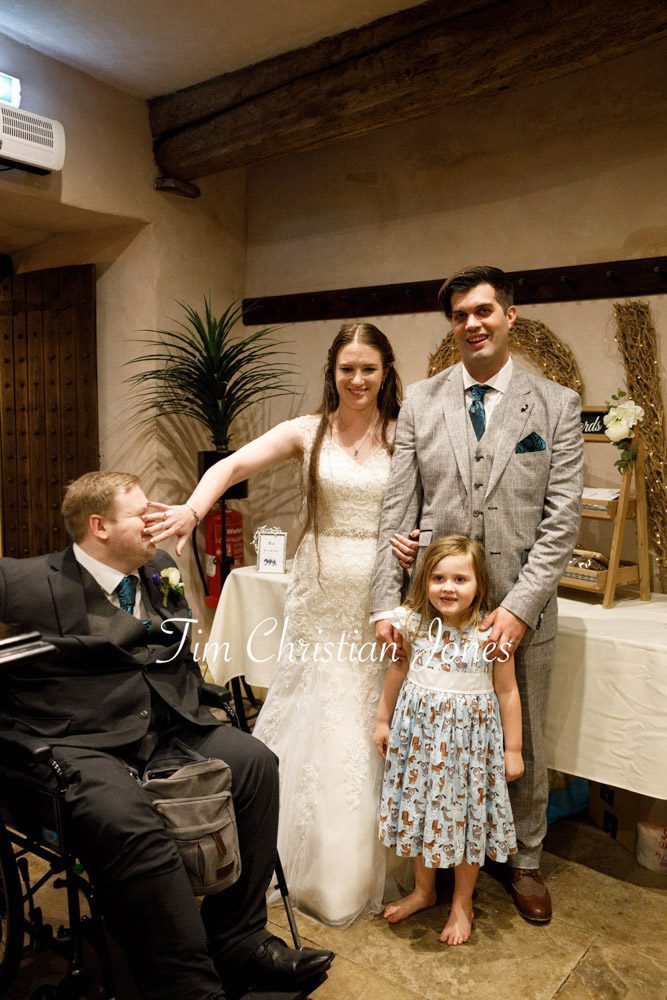 Funny moment as best man photobombs family group photo.