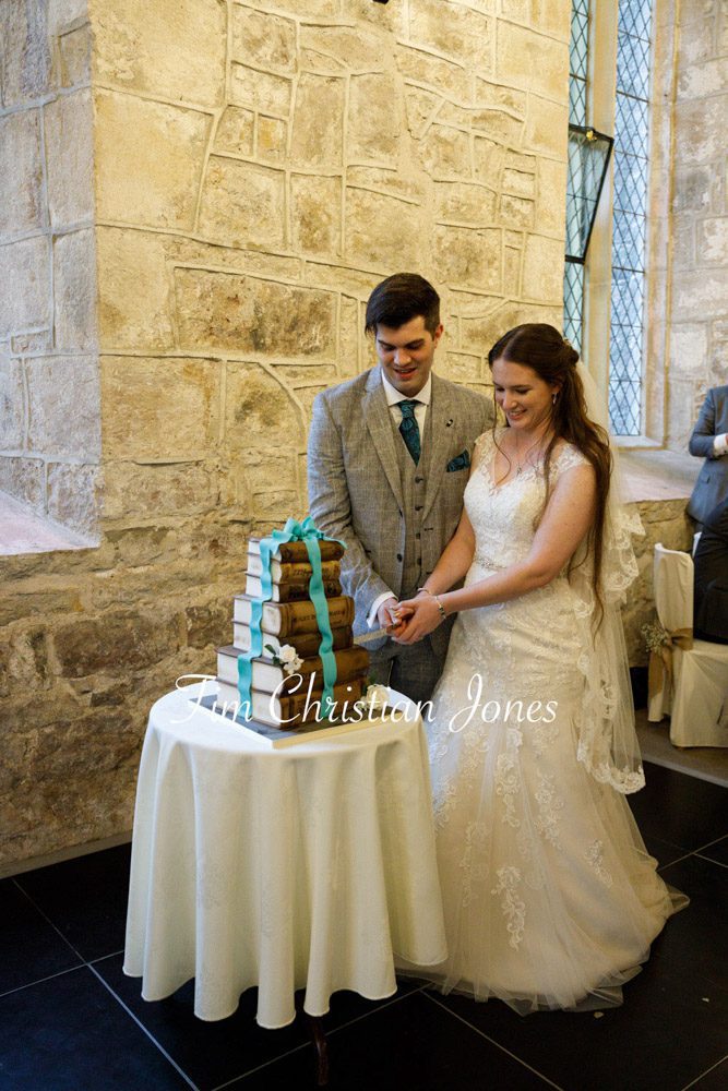 Fun moment cutting the stacked book style wedding cake.